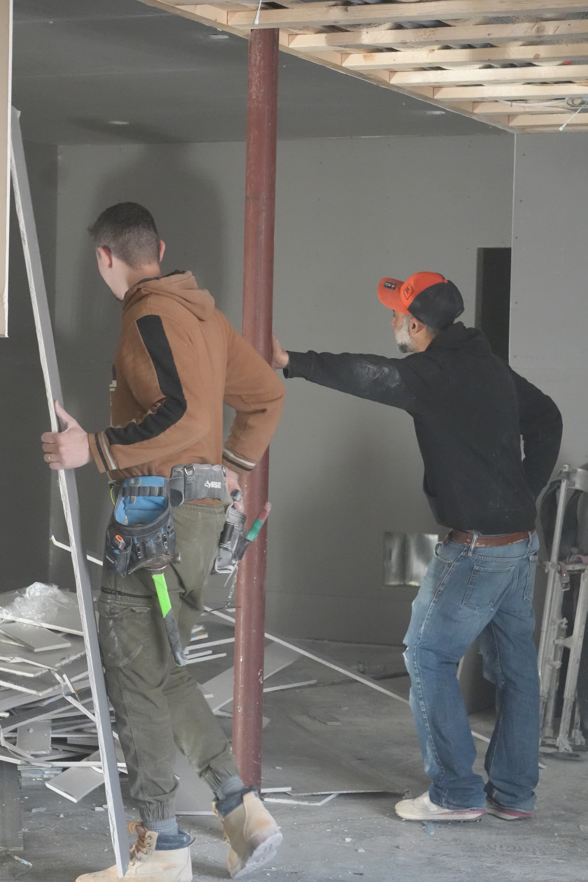Crew lifting blueboard sheet into position — teamwork