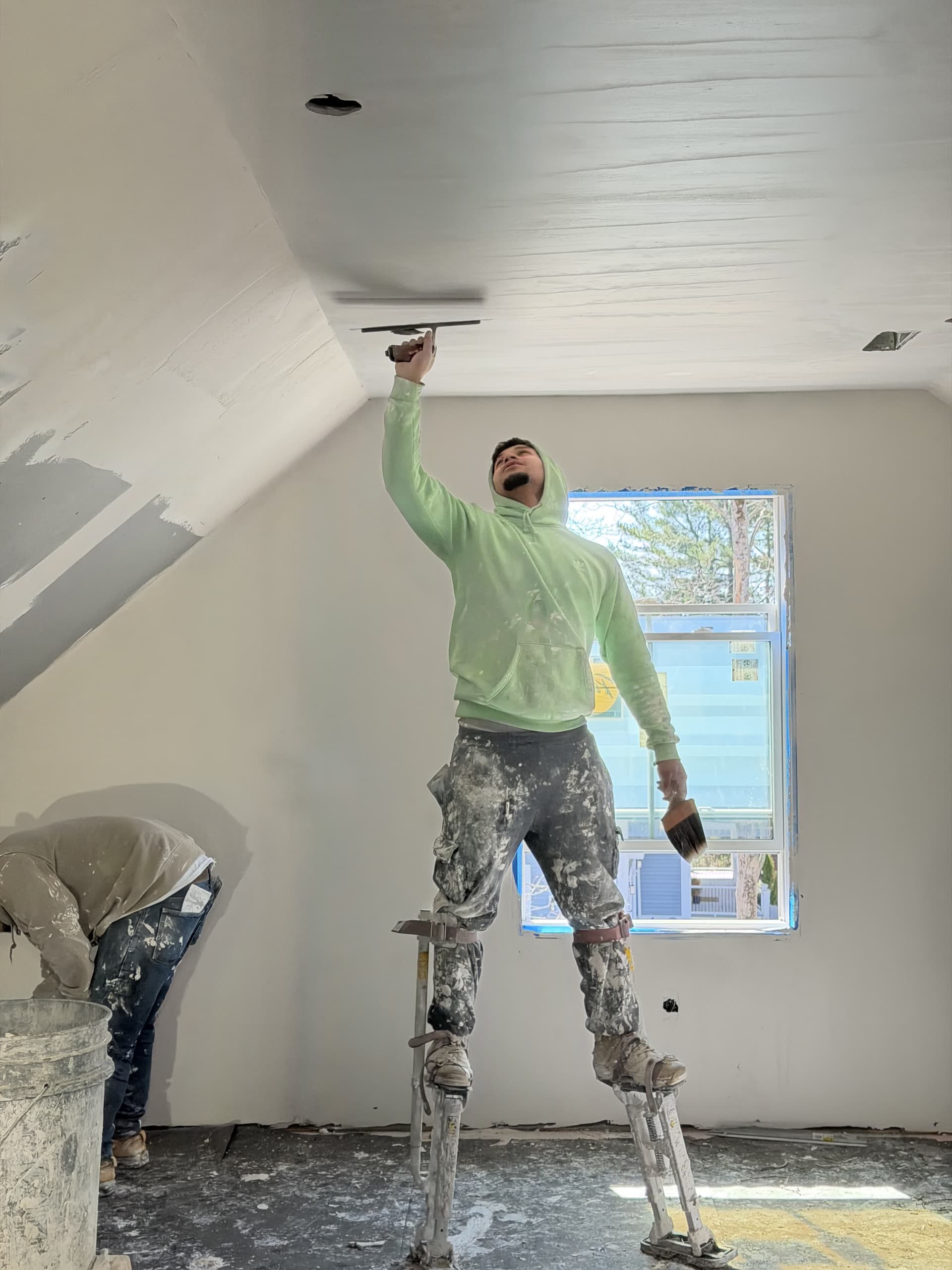 Plasterer on stilts finishing vaulted ceiling — MetroWest MA