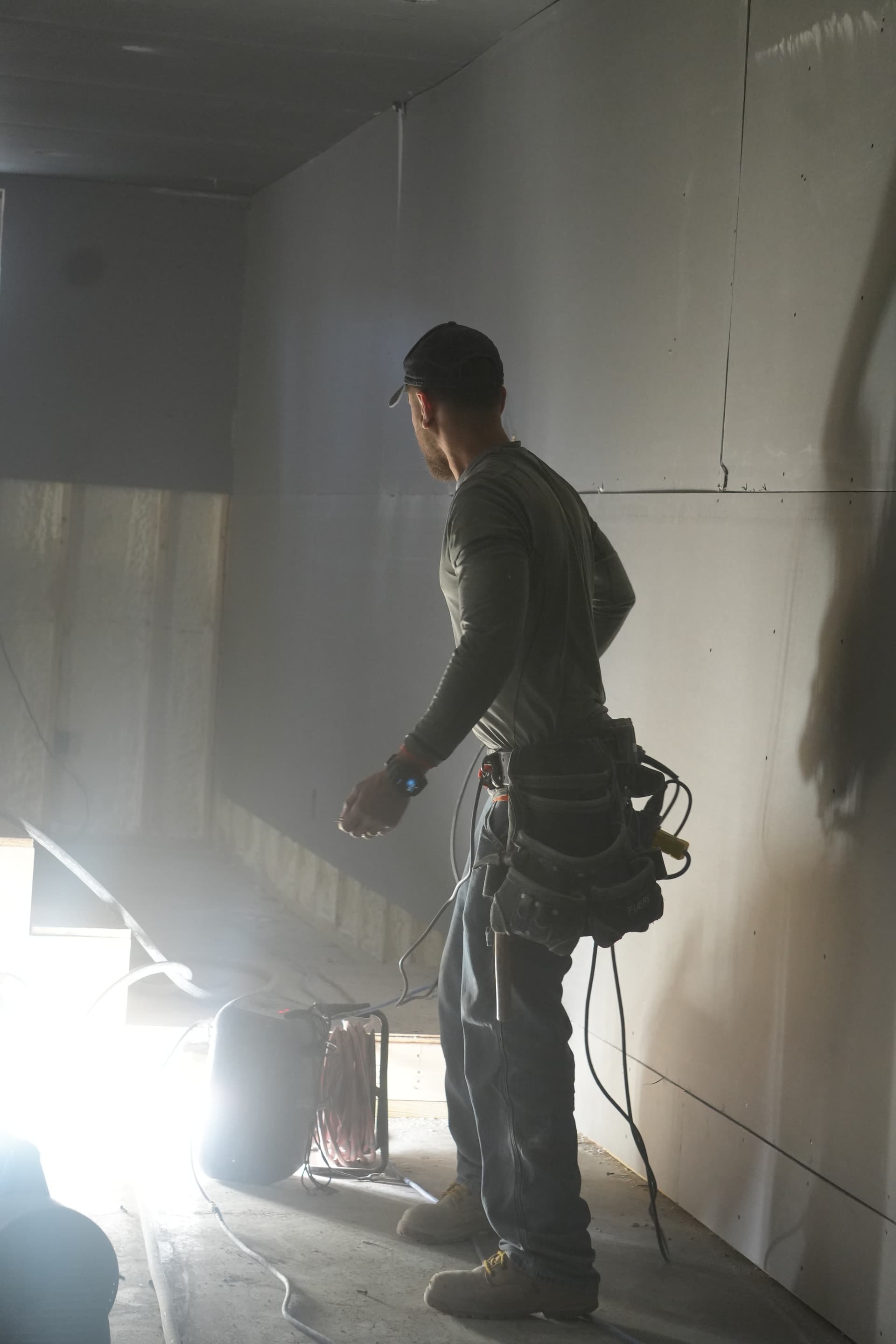 Worker plastering in freshly finished room with tools