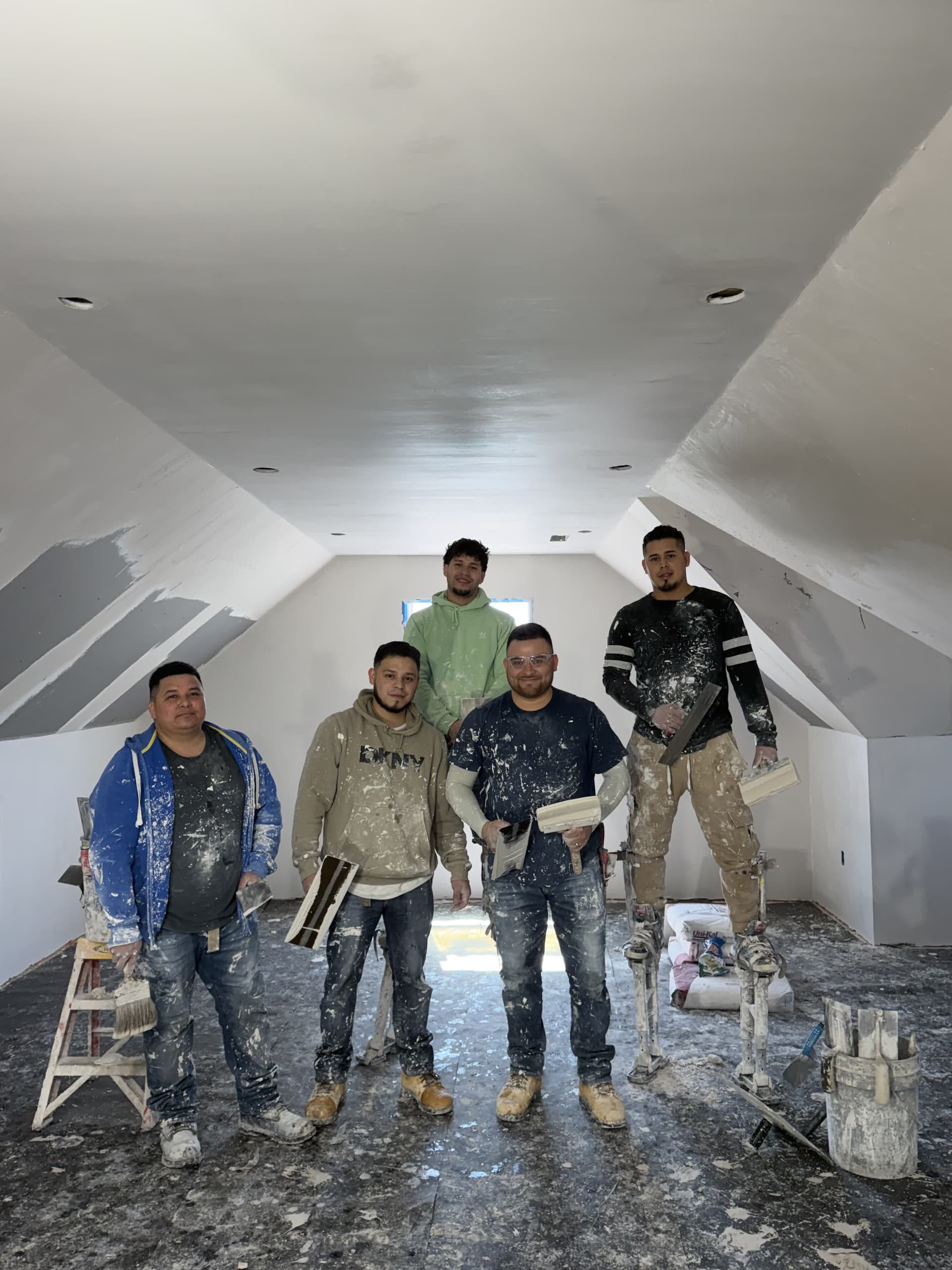 Five-man plastering crew in finished vaulted room
